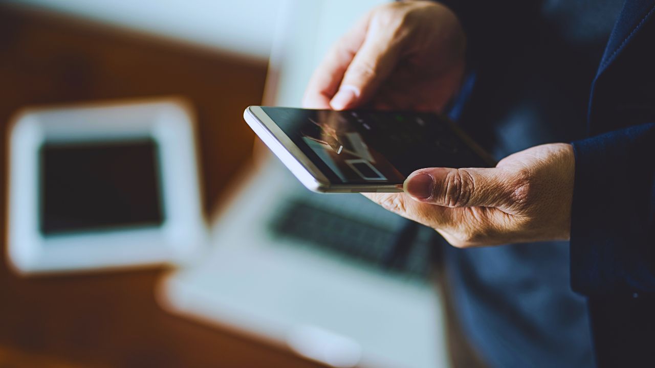 Person watching a video on a smartphone with a blurred background, highlighting how media time can generate earnings.